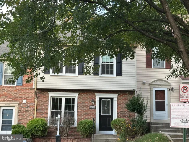 a front view of a house with plants and trees