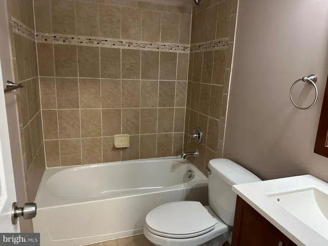a white toilet and tub sitting next to a bathroom sink