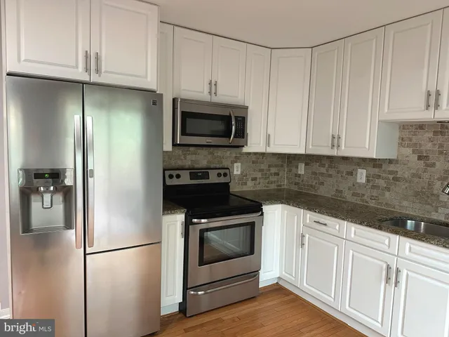 a kitchen with white cabinets and stainless steel appliances