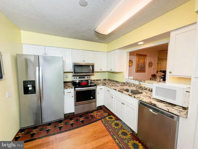 a kitchen with stainless steel appliances a stove a sink and a refrigerator