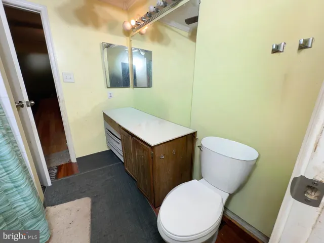 a bathroom with a toilet a sink a vanity and mirror