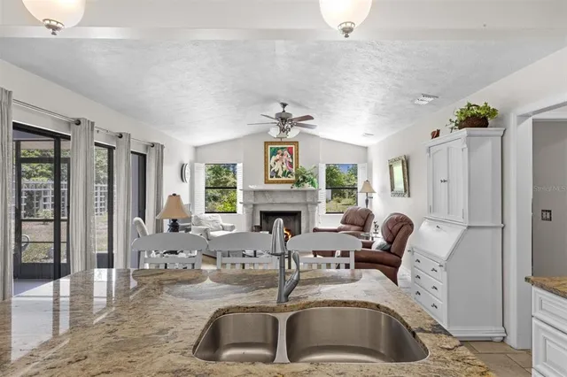 a kitchen with stainless steel appliances granite countertop a sink a stove a refrigerator and cabinets