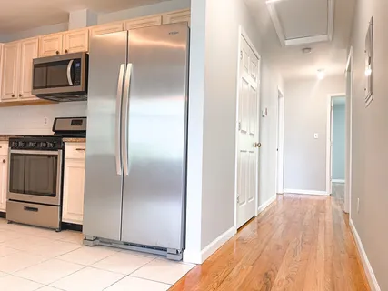 a kitchen with stainless steel appliances kitchen island granite countertop a refrigerator and a stove top oven