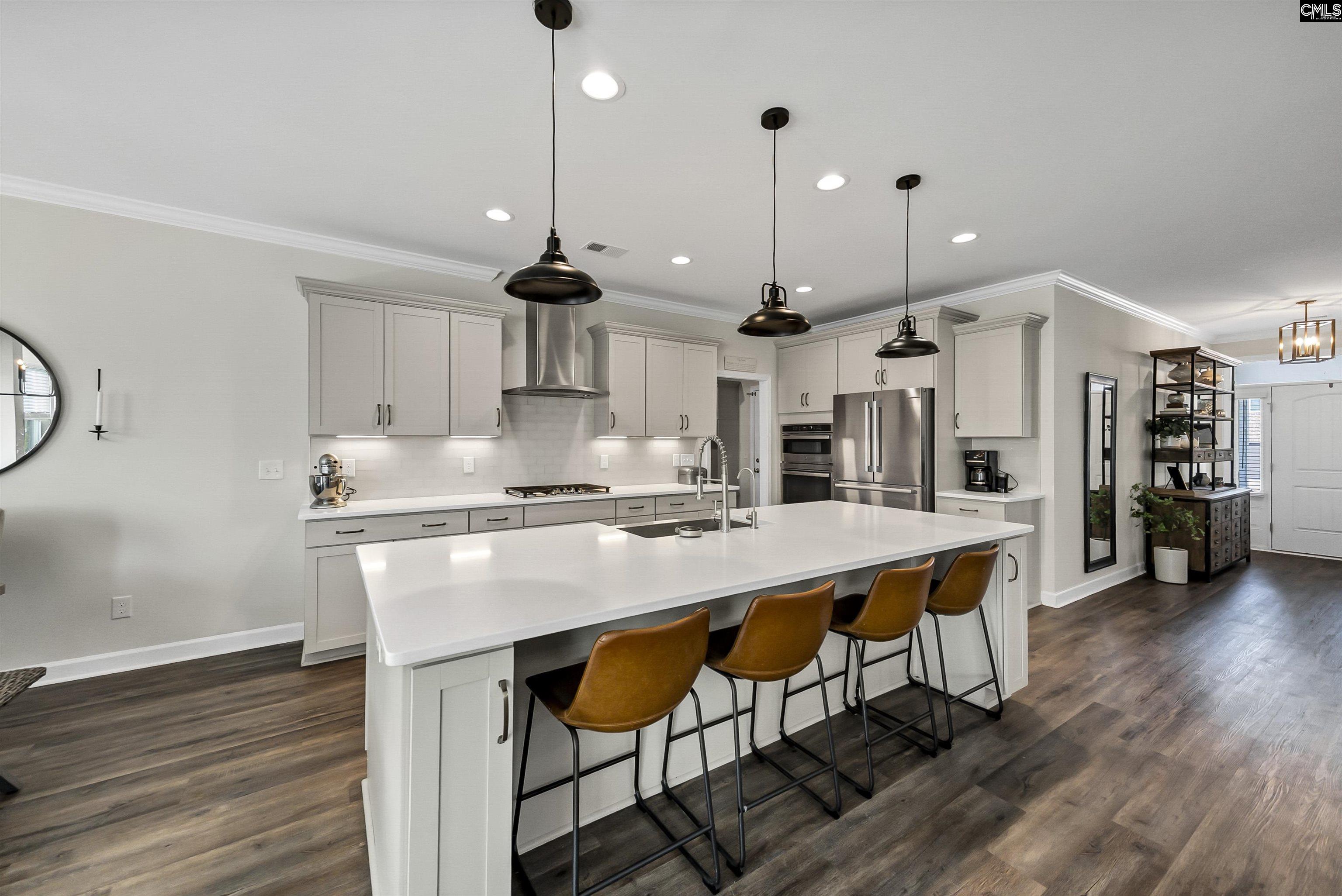 515 Malachite Lane Chapin, SC 29036 - Photo 10 of 63 a kitchen with stainless steel appliances granite countertop a stove a refrigerator a oven a sink with island and chairs with wooden floor