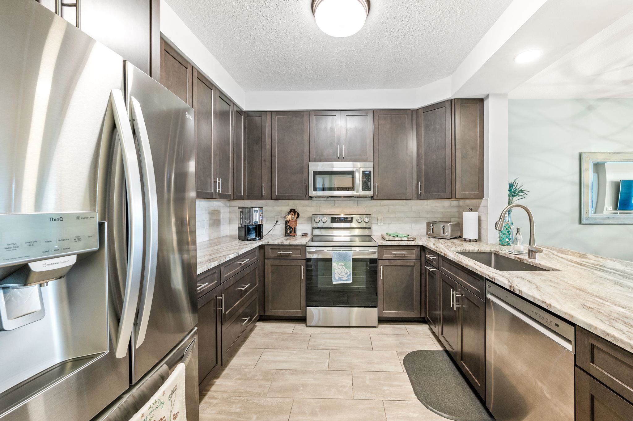 285 Atlantis Circle, Unit 203 St. Augustine, FL 32080 - Photo 11 of 66 a kitchen with stainless steel appliances granite countertop a sink stove and refrigerator