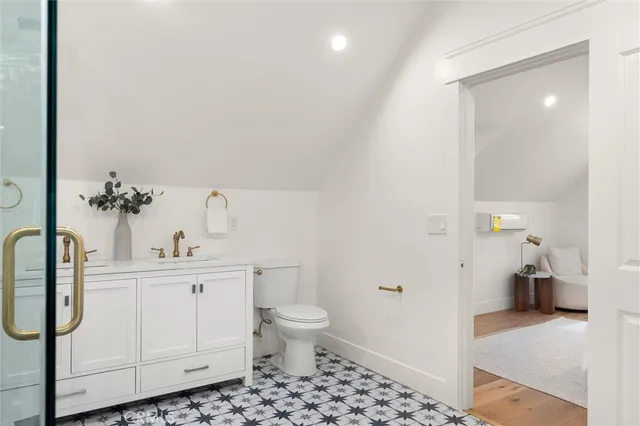 a bathroom with a sink a toilet and a view of bathroom