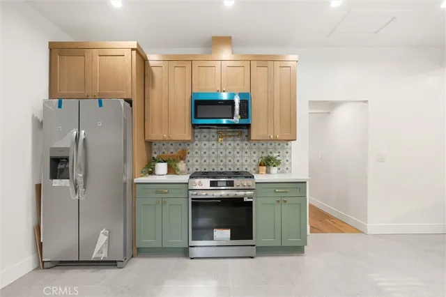 a kitchen with stainless steel appliances granite countertop a refrigerator and a stove
