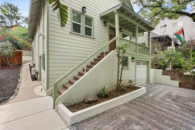 a view of a house with a small yard and potted plants