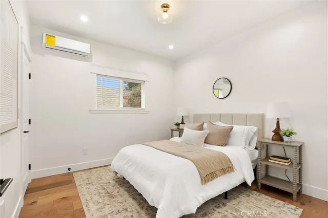 a bedroom with a bed and painting on the wall