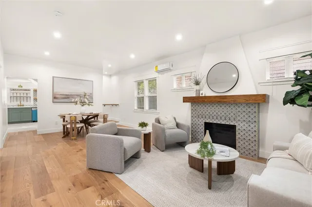 a living room with furniture a fireplace and a large window