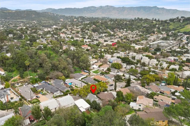 an aerial view of a house with swimming pool and outdoor seating