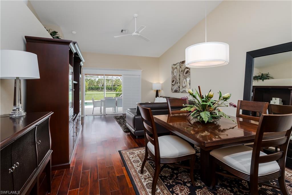 6658 Castlelawn Place, Unit 9 Naples, FL 34113 - Photo 12 of 38 Dining area featuring wood-finish flooring, a contemporary drum pendant light, and a large wall mirror