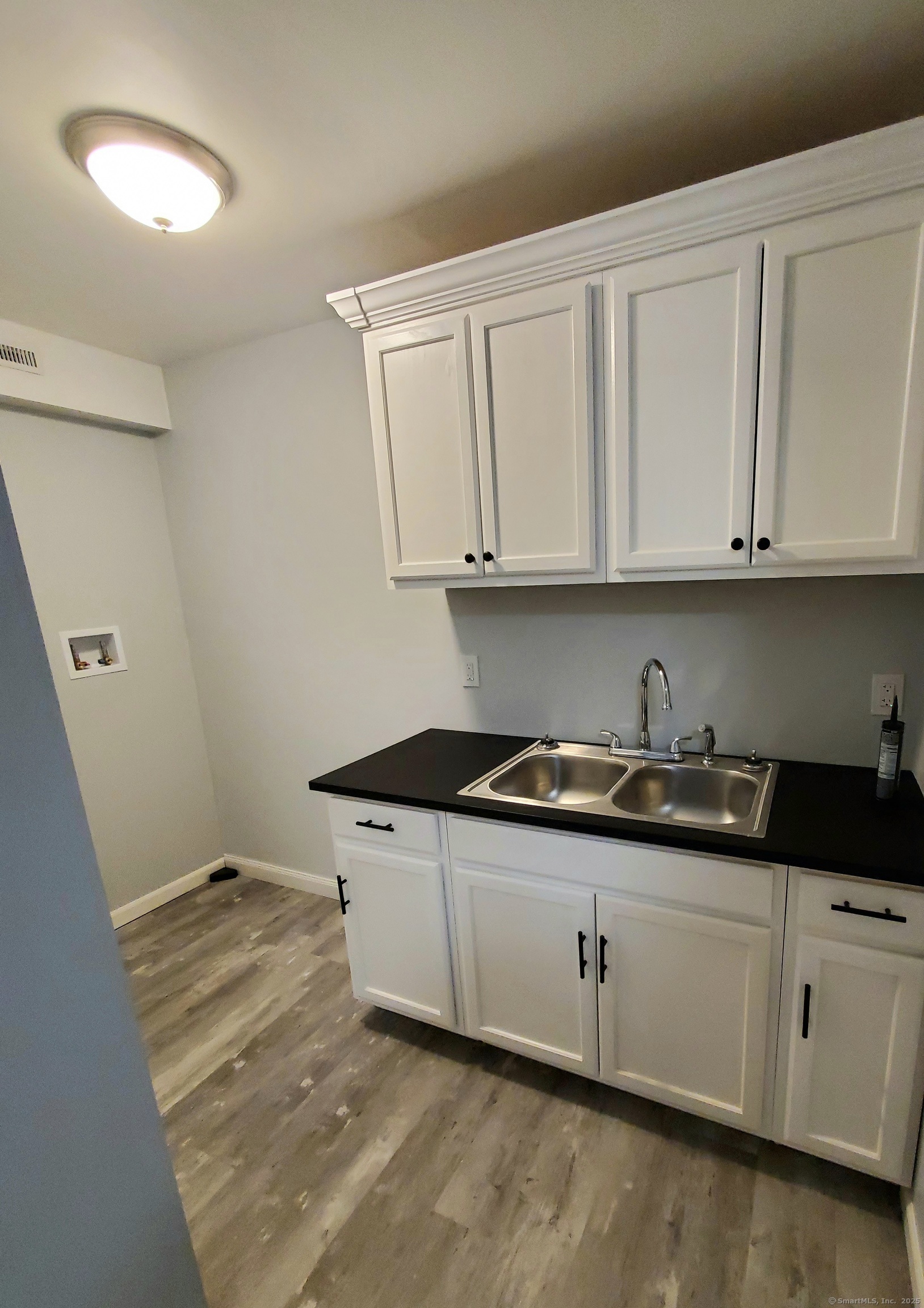 402 Huntington Street New Haven, CT 06511 - Photo 2 of 12 a kitchen with granite countertop white cabinets and sink