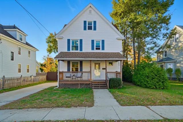 a front view of a house with a yard and trees