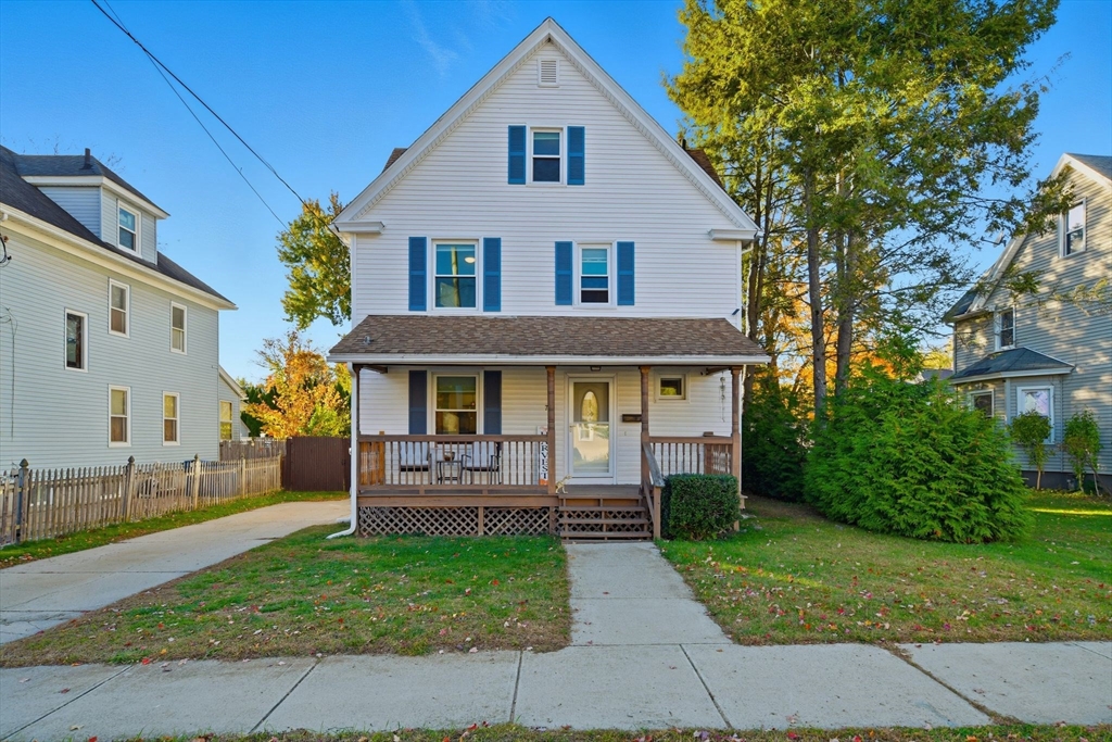 a front view of a house with a yard and trees