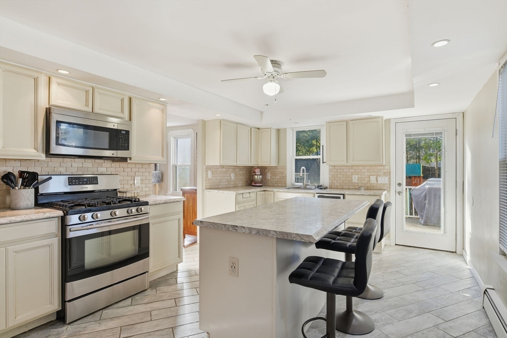 73 Maple Terrace West Springfield, MA 01089 - Photo 11 of 41 a kitchen with kitchen island a stove a microwave a dining table and chairs