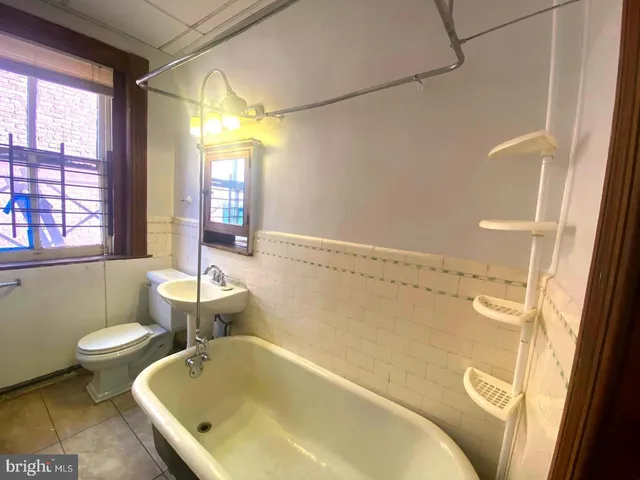 a bathroom with a tub a sink and a large window
