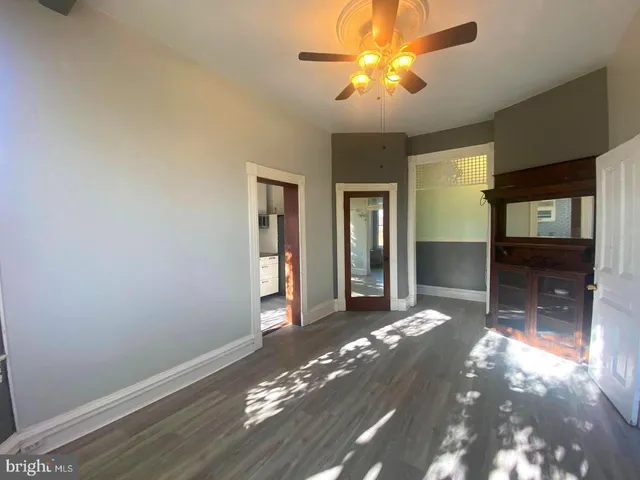 a view of a livingroom with a chandelier fan and a window