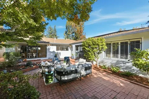 a view of a patio with table and chairs and potted plants