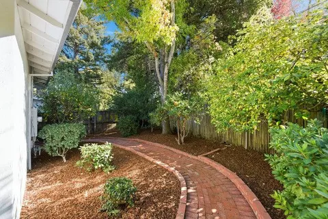a front view of a house with a yard and trees