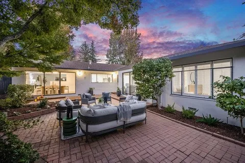 a view of a house with backyard and sitting area