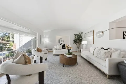 a living room with patio furniture and a floor to ceiling window