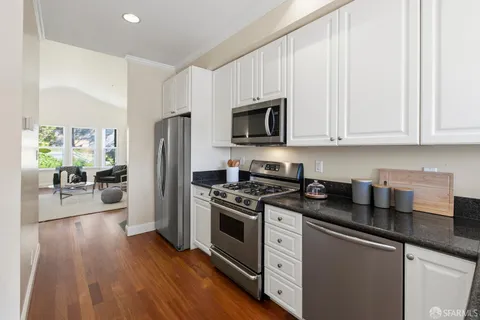 a kitchen with stainless steel appliances granite countertop a stove a sink and a microwave