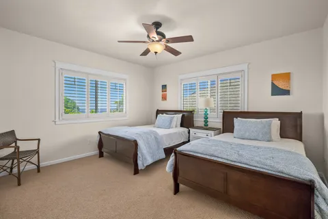 a bedroom with two beds and window