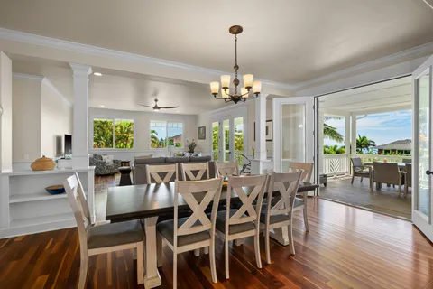 a view of a dining room and livingroom with lots of furniture wooden floor a chandelier