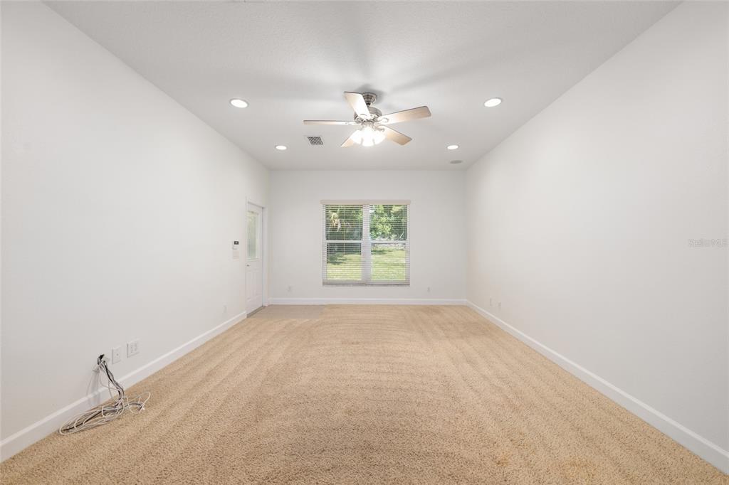 4735 Southeast 112th Street Road Belleview, FL 34420 - Photo 38 of 73 an empty room with a window and a ceiling fan