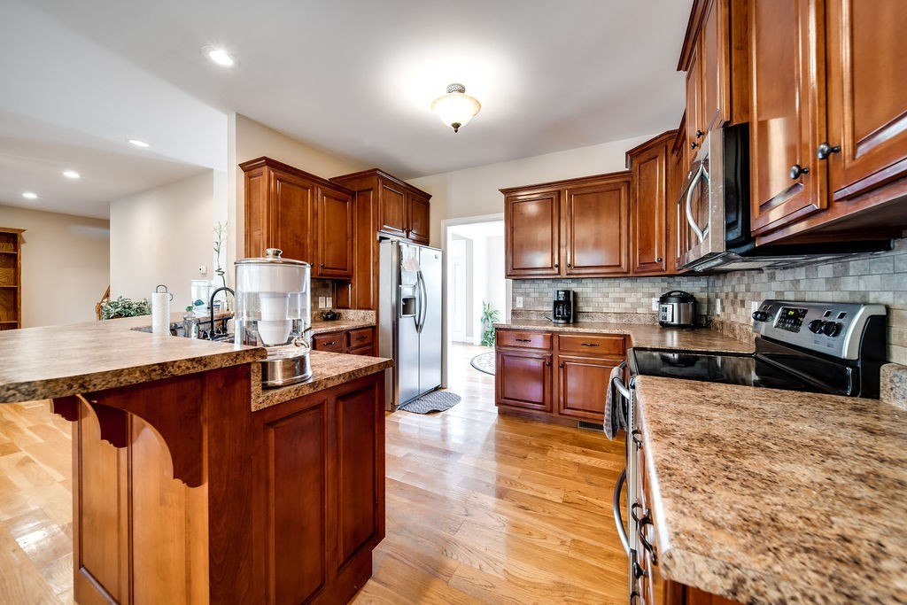 181 Dry Fork Road South Bethpage, TN 37022 - Photo 21 of 52 a kitchen with stainless steel appliances granite countertop a stove top oven a sink dishwasher a dining table and chairs with wooden floor