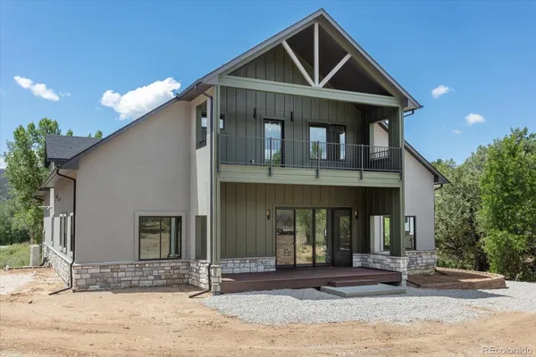 a kitchen with stainless steel appliances kitchen island granite countertop a stove a sink a refrigerator and white cabinets with wooden floor