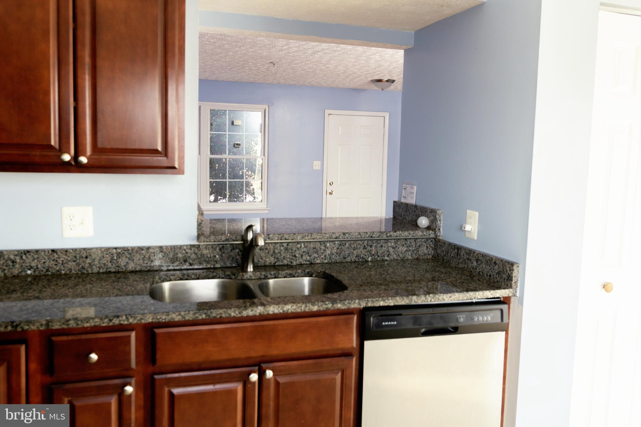2323 Bluegrass Heights Court Rosedale, MD 21237 - Photo 4 of 14 a kitchen with granite countertop a sink and cabinets