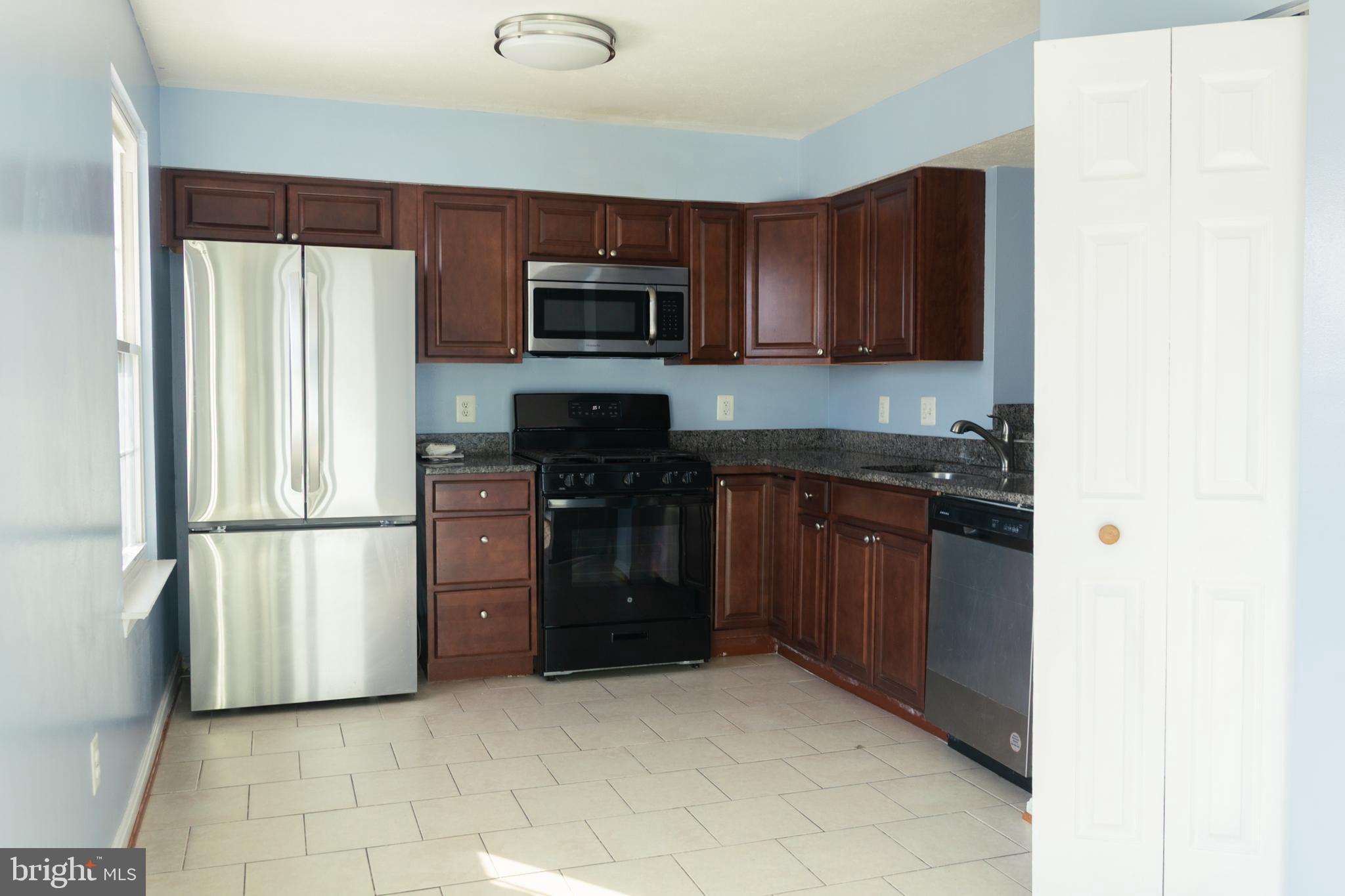 2323 Bluegrass Heights Court Rosedale, MD 21237 - Photo 8 of 14 a kitchen with stainless steel appliances granite countertop a refrigerator stove a sink and dishwasher