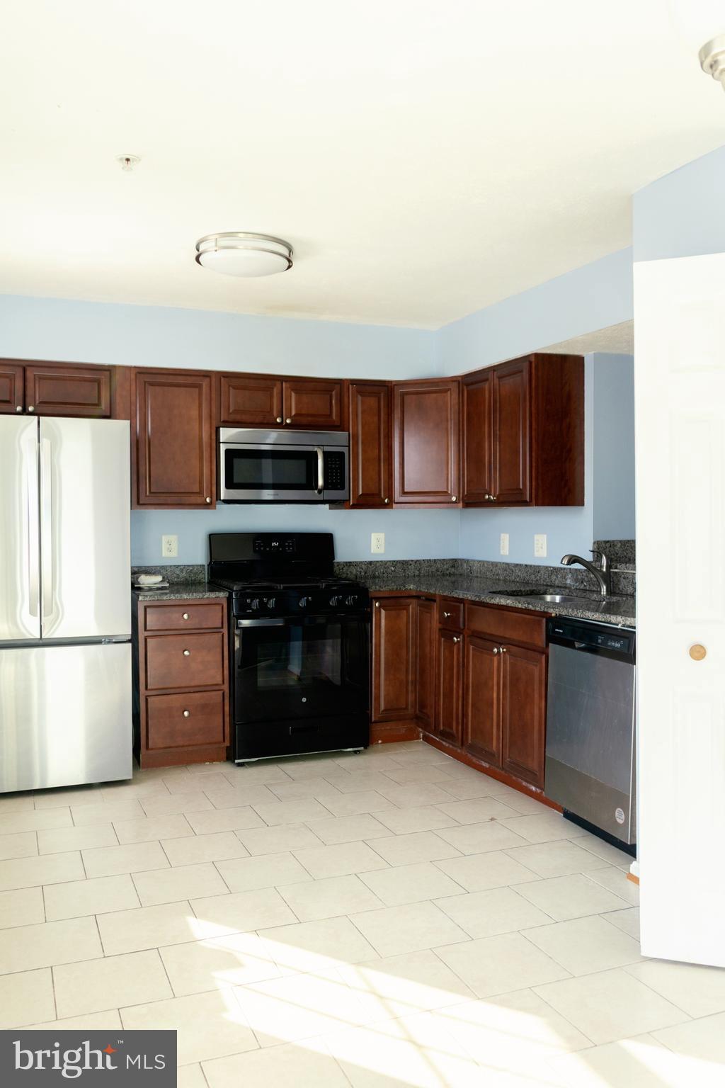 2323 Bluegrass Heights Court Rosedale, MD 21237 - Photo 9 of 14 a kitchen with stainless steel appliances and cabinets