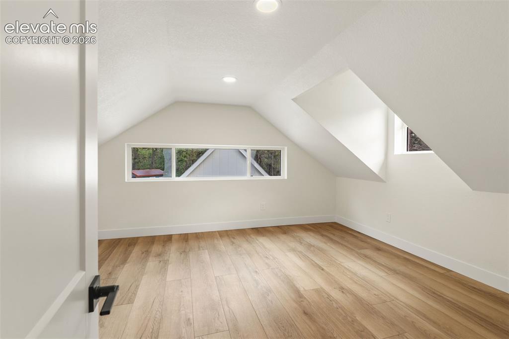 11665 Greentree Road Colorado Springs, CO 80908 - Photo 25 of 43 Bedroom with character, featuring vaulted ceiling, light wood finished floors, and recessed lighting