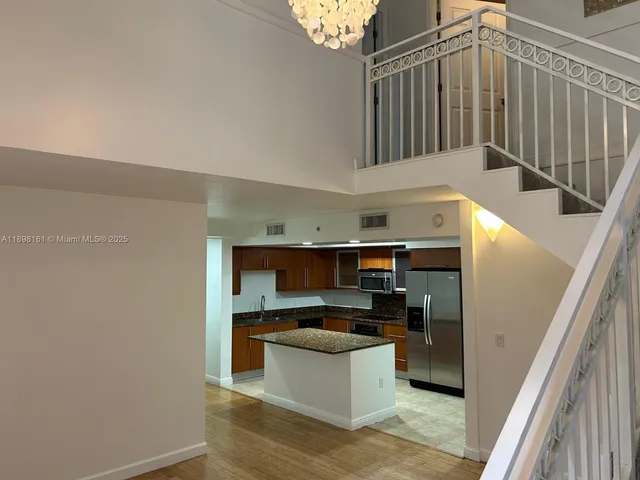 a kitchen with stainless steel appliances kitchen island a refrigerator sink and stove