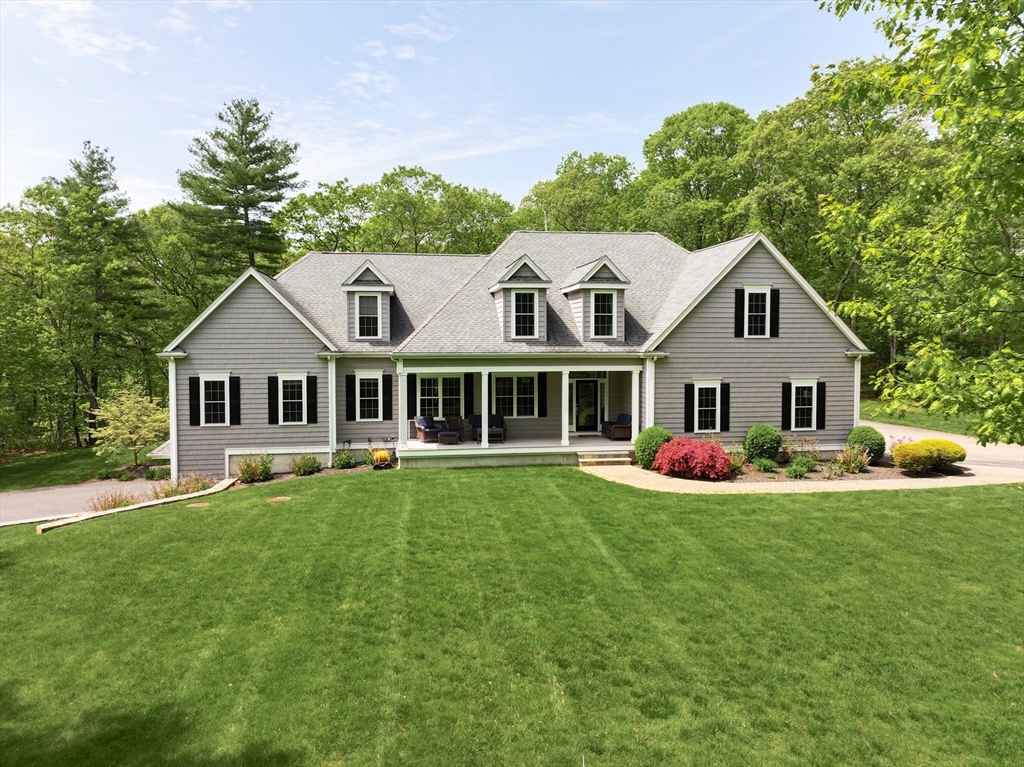 a front view of a house with a garden and trees