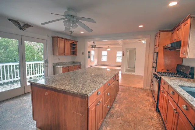 a kitchen with stainless steel appliances granite countertop a stove a sink dishwasher and a refrigerator with wooden floor