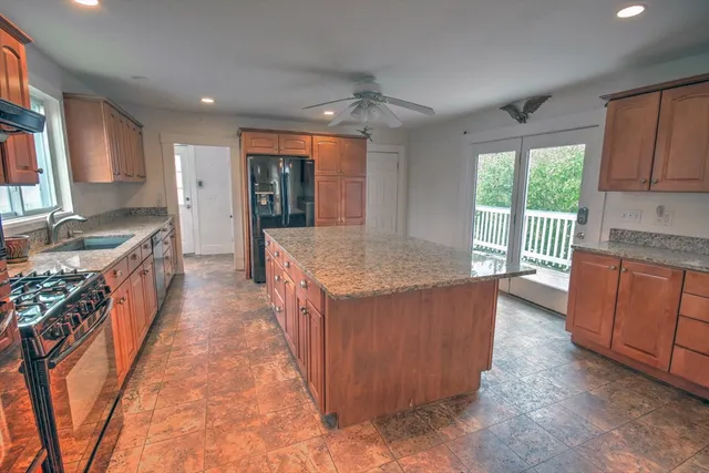 a large kitchen with kitchen island granite countertop a large counter top and stainless steel appliances
