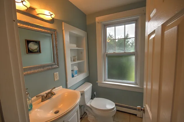 a bathroom with a toilet a sink and mirror