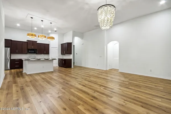 a kitchen with granite countertop a sink and a stove top oven with wooden floor