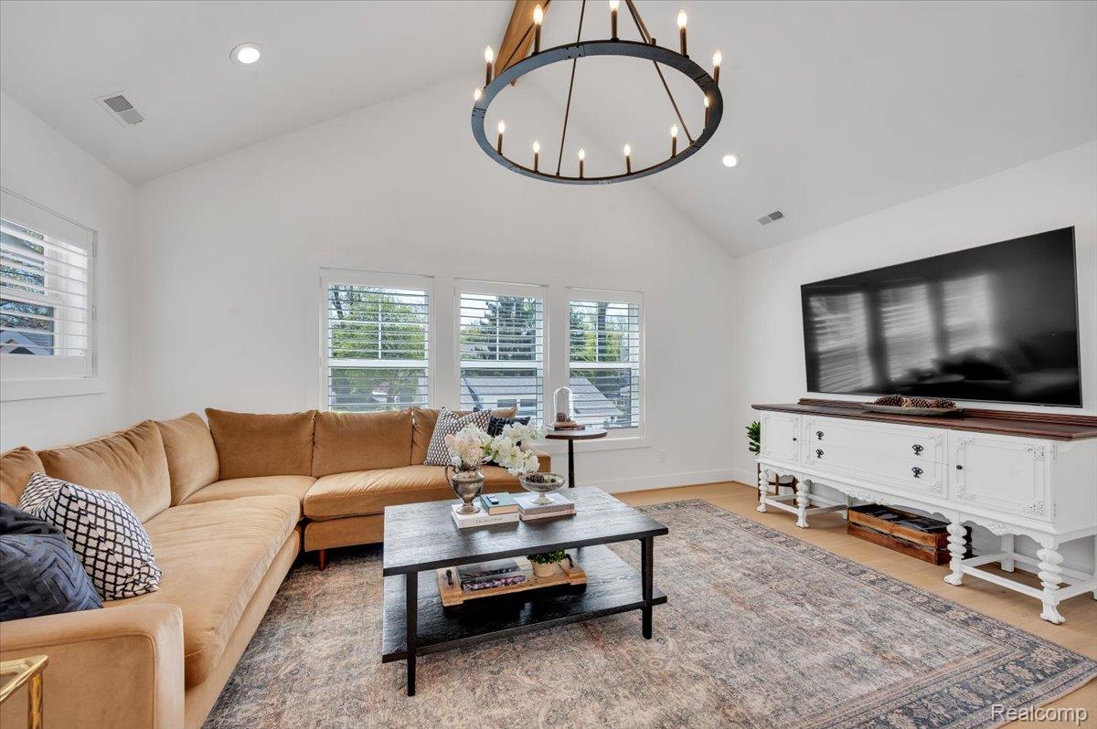 332 Highland Avenue Rochester, MI 48307 - Photo 21 of 39 Living area with vaulted ceiling, a chandelier, and light wood finished floors