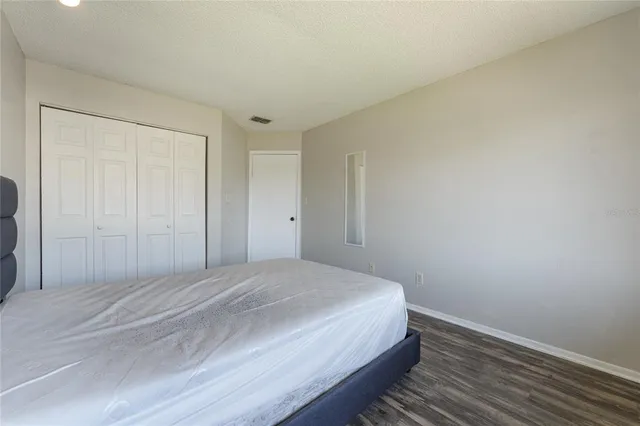 a bedroom with a bed and a painting on the wall