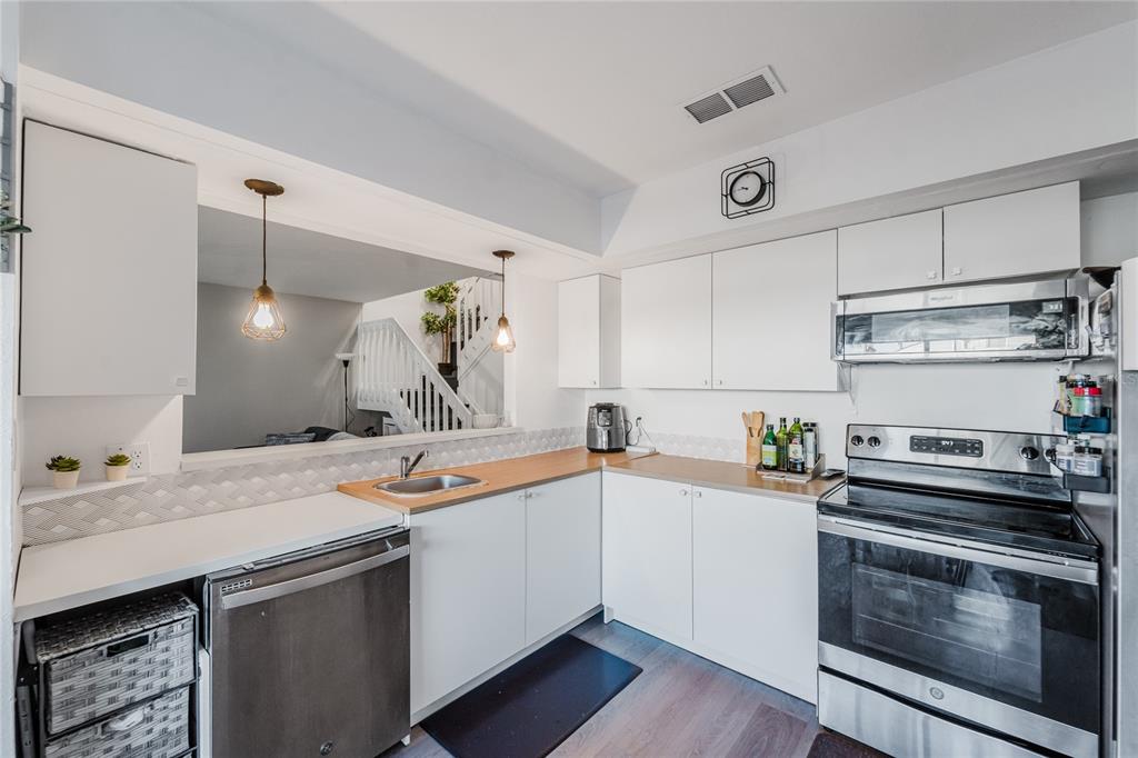 4413 Ring Neck Road, Unit 4413 Orlando, FL 32808 - Photo 7 of 24 a kitchen with a sink stove and cabinets