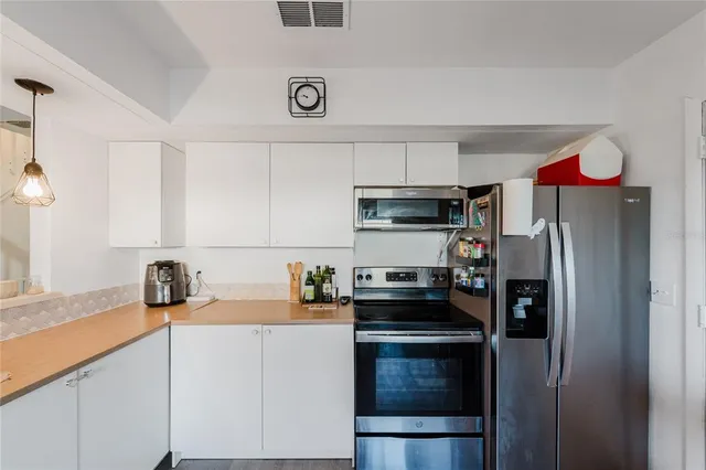 a kitchen with stainless steel appliances a sink stove and refrigerator