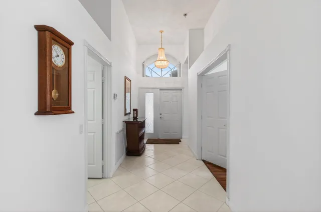 a hallway with painting and a chandelier