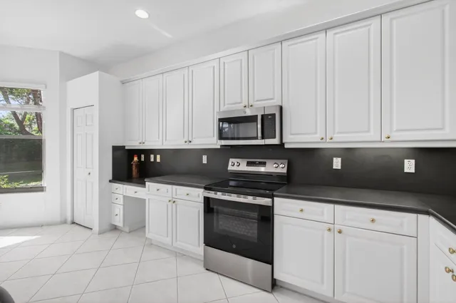 a kitchen with white cabinets and appliances