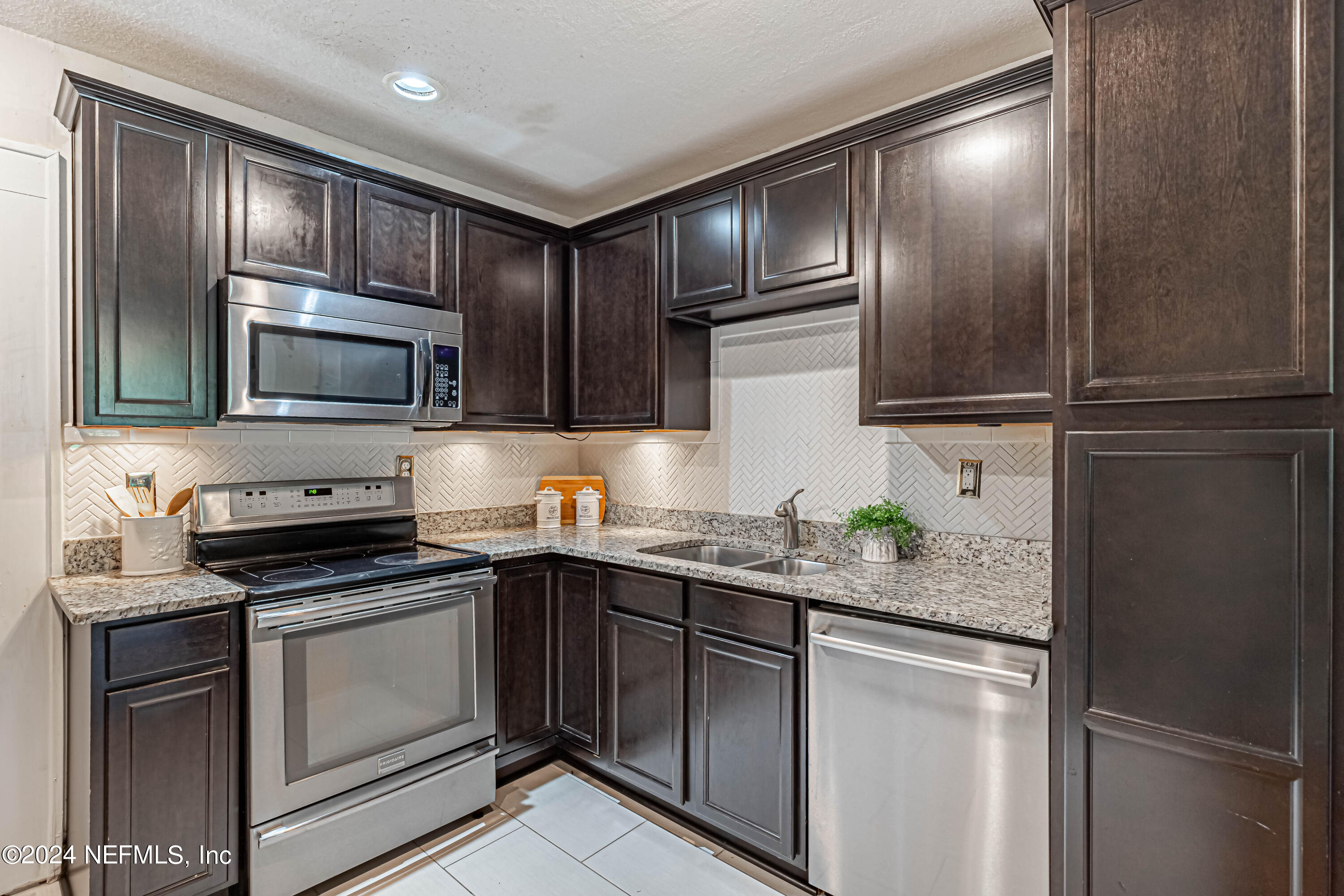 725 Cherokee Street Jacksonville, FL 32205 - Photo 17 of 41 a kitchen with stainless steel appliances granite countertop a stove a sink and a microwave