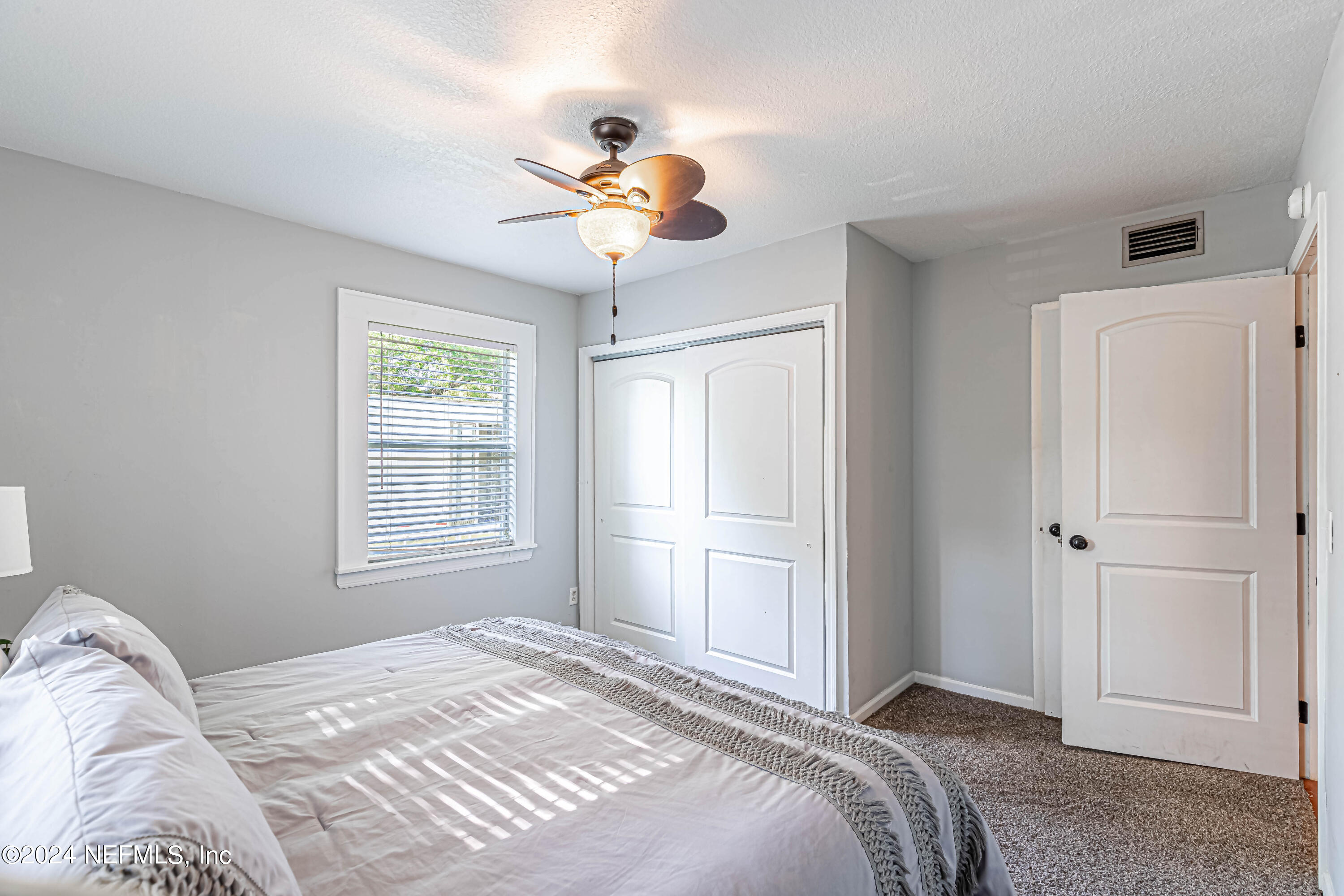 725 Cherokee Street Jacksonville, FL 32205 - Photo 28 of 41 a bedroom with a bed and a chandelier
